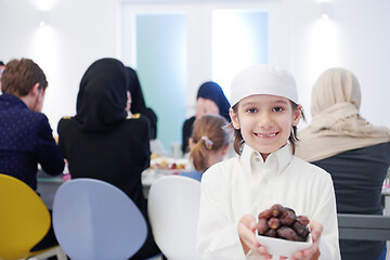 Image showing little muslim boy holding a plate full of sweet dates