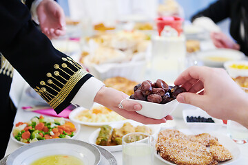 Image showing Muslim family having Iftar dinner eating dates to break feast