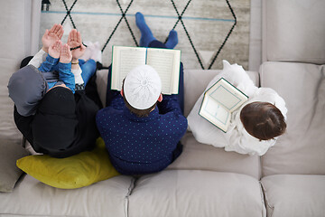 Image showing muslim family reading Quran and praying at home top view