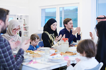 Image showing traditional muslim family praying before iftar dinner