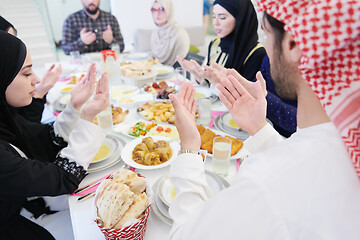 Image showing traditional muslim family praying before iftar dinner