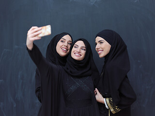 Image showing muslim women taking selfie picture in front of black chalkboard