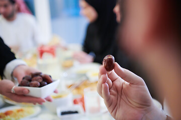 Image showing Muslim family having Iftar dinner eating dates to break feast