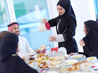 Image showing Muslim family having Iftar dinner drinking water to break feast