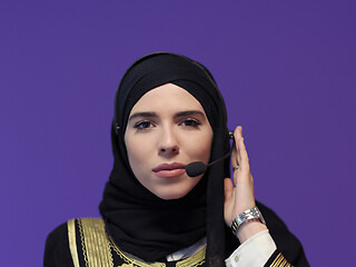 Image showing portrait of muslim woman with headset on purple background