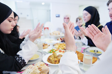 Image showing traditional muslim family praying before iftar dinner