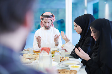 Image showing traditional muslim family praying before iftar dinner