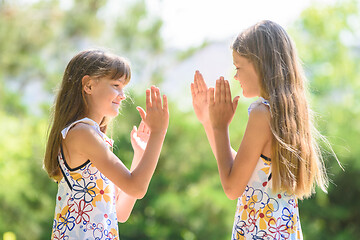 Image showing Children play ladlets walking in a city park, close-up