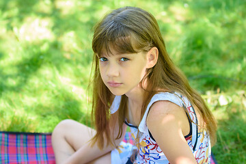 Image showing Portrait of a little sad girl on a picnic in a green park