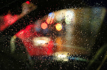 Image showing Lights of night city through the glass of the car with raindrops