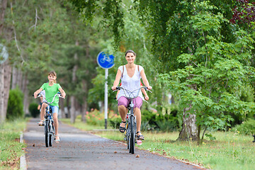 Image showing Mom and daughter ride a bike in the park