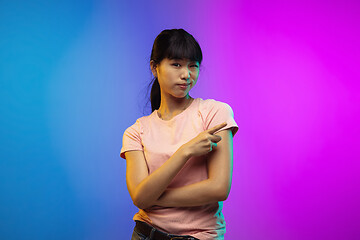 Image showing Asian young woman\'s portrait on gradient studio background in neon