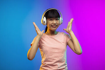 Image showing Asian young woman\'s portrait on gradient studio background in neon
