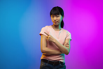 Image showing Asian young woman\'s portrait on gradient studio background in neon