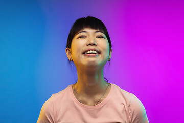 Image showing Asian young woman\'s portrait on gradient studio background in neon