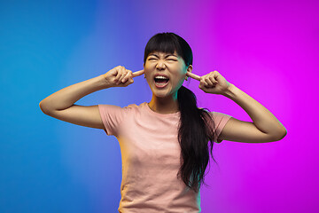 Image showing Asian young woman\'s portrait on gradient studio background in neon