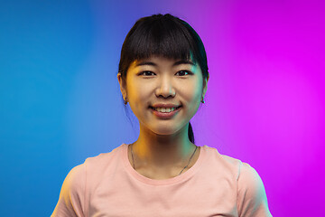 Image showing Asian young woman\'s portrait on gradient studio background in neon