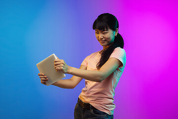 Image showing Asian young woman\'s portrait on gradient studio background in neon