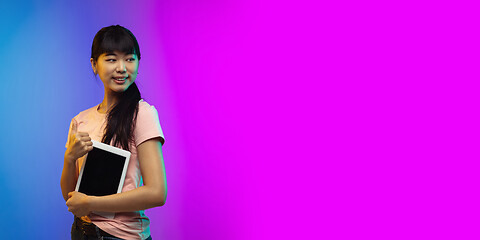 Image showing Asian young woman\'s portrait on gradient studio background in neon