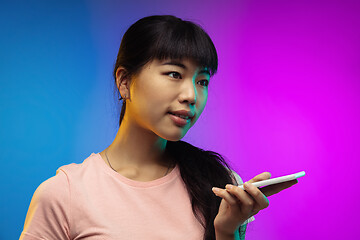 Image showing Asian young woman\'s portrait on gradient studio background in neon