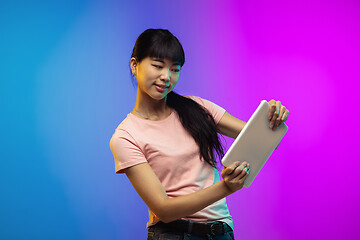 Image showing Asian young woman\'s portrait on gradient studio background in neon