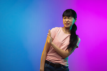 Image showing Asian young woman\'s portrait on gradient studio background in neon