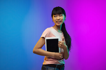 Image showing Asian young woman\'s portrait on gradient studio background in neon