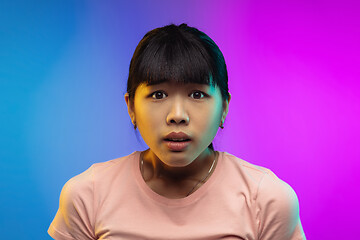 Image showing Asian young woman\'s portrait on gradient studio background in neon