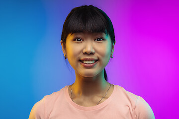 Image showing Asian young woman\'s portrait on gradient studio background in neon