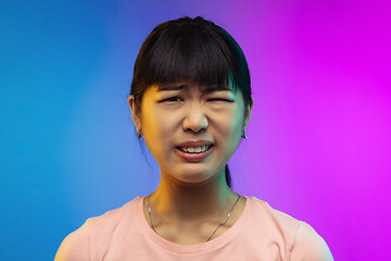 Image showing Asian young woman\'s portrait on gradient studio background in neon