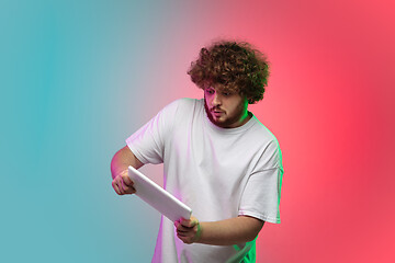 Image showing Caucasian young man\'s portrait on gradient studio background in neon