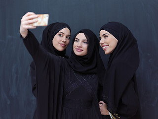 Image showing muslim women taking selfie picture in front of black chalkboard