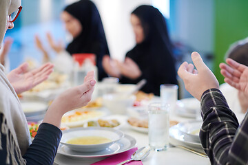 Image showing traditional muslim family praying before iftar dinner