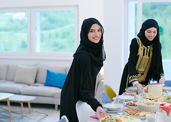 Image showing young muslim girls serving food on the table for iftar dinner