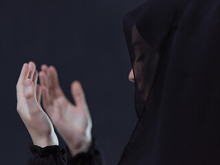 Image showing muslim woman making traditional prayer to God in front of black 