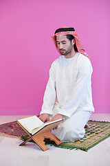 Image showing young arabian muslim man reading Quran at home