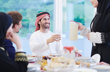 Image showing Muslim family having Iftar dinner drinking water to break feast