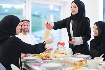 Image showing Muslim family having Iftar dinner drinking water to break feast