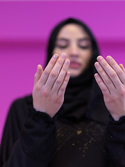 Image showing muslim woman making traditional prayer to God isolated on pink