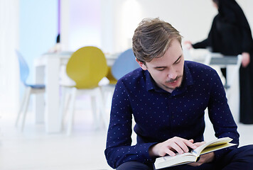 Image showing young muslim man reading Quran at home