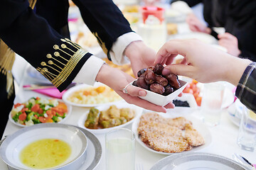 Image showing Muslim family having Iftar dinner eating dates to break feast