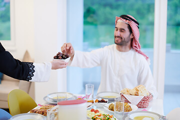 Image showing Muslim family having Iftar dinner eating dates to break feast