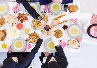 Image showing Muslim family having Iftar dinner eating dates to break feast to