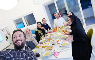 Image showing Muslim family having Iftar dinner taking pictures with mobile ph