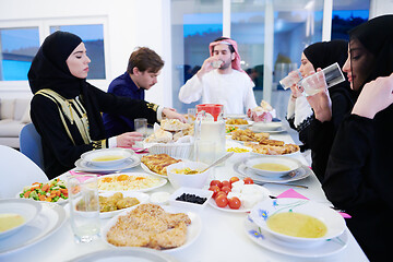 Image showing Muslim family having Iftar dinner drinking water to break feast