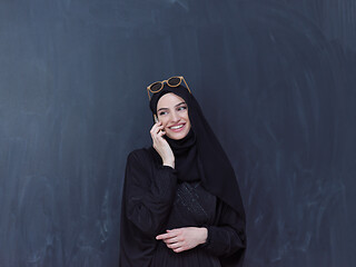 Image showing young muslim woman wearing sunglasses using smartphone