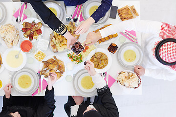 Image showing Muslim family having Iftar dinner eating dates to break feast to