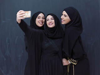 Image showing muslim women taking selfie picture in front of black chalkboard