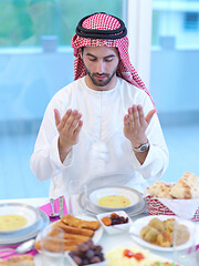 Image showing arabian man making traditional prayer to God before iftar dinner