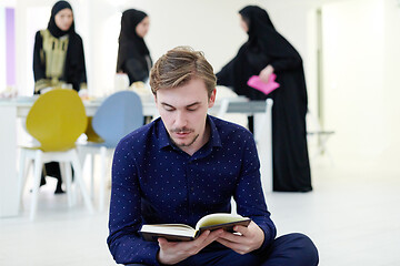 Image showing young muslim man reading Quran at home